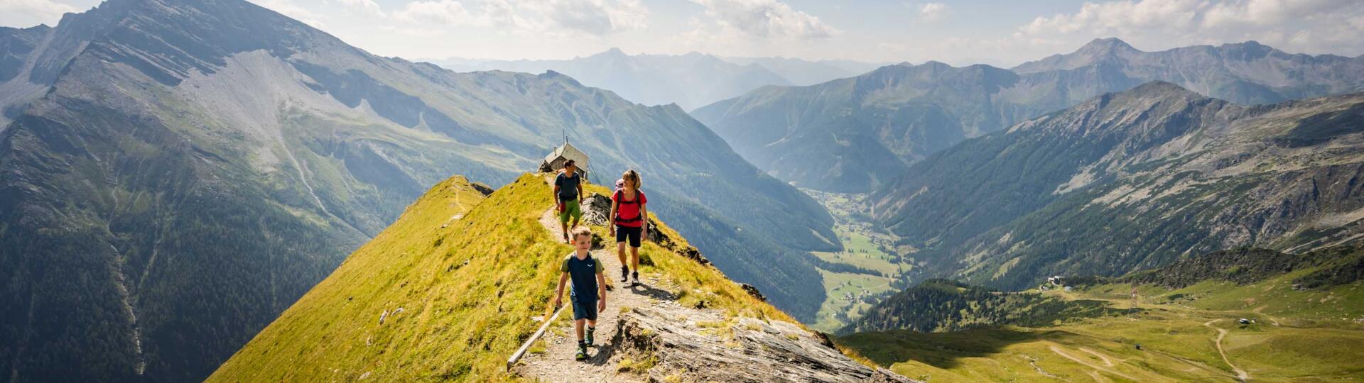 Familie wandert auf einem Berggrat mit Panoramablick