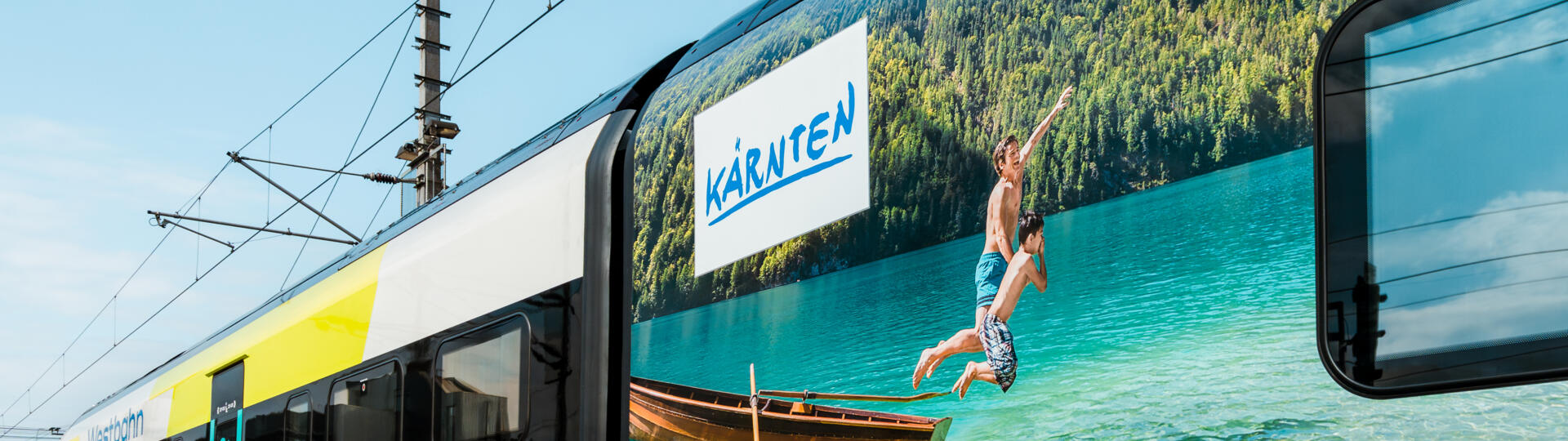 Regionalzug mit Werbemotiv, das Kinder beim Baden zeigt