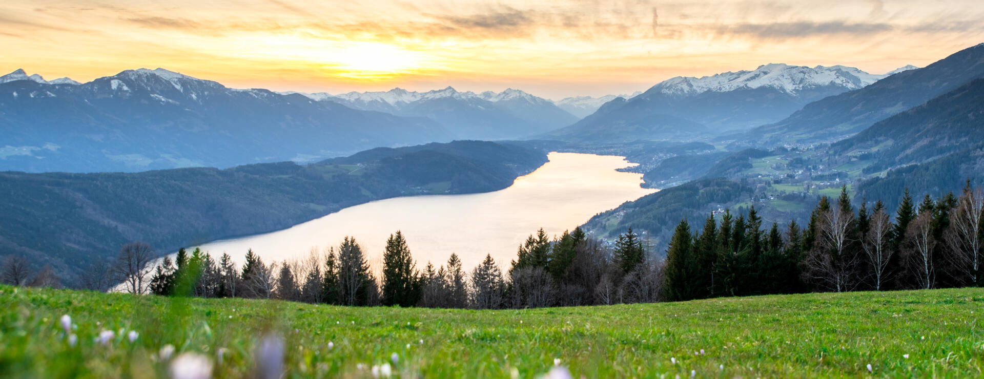 Panoramablick über die Kärntner Berg- und Seenlandschaft bei Sonnenaufgang 