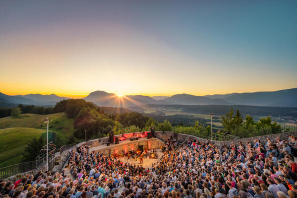 4_Kärnten Werbung GmbH_Tine Steinthaler Freiluftveranstaltung mit Publikum vor Bergkulisse bei Sonnenuntergang