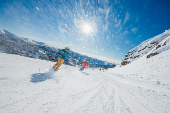 Zwei Skifahrer auf einer verschneiten Piste in den Kärntner Alpen